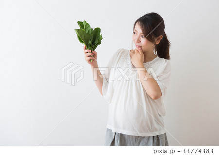 ほうれん草を持つ妊婦さん 33774383
