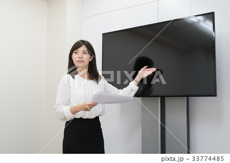 会議室でプレゼンする女性社員 会議室でプレゼンする女性社員 33774485