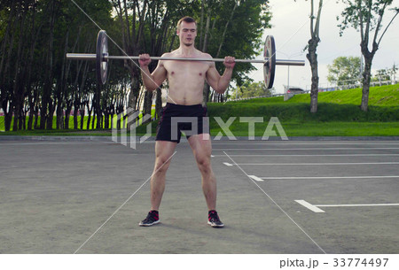 A young man is lifting barbell A young man is lifting barbell 33774497