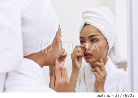 Asian woman with bath towels cleanses her face Asian woman with bath towels cleanses her face 33776905