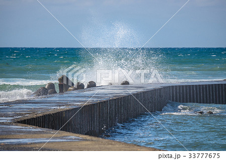防波堤に打ち寄せる波の写真素材