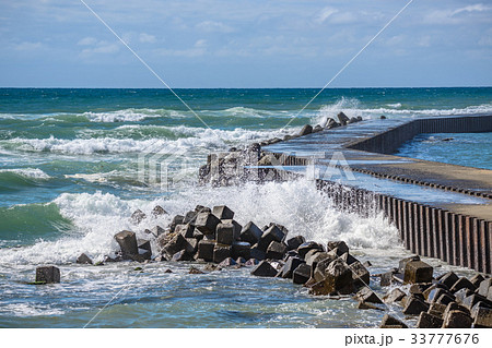 防波堤に打ち寄せる波の写真素材