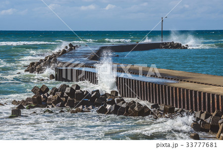 防波堤に打ち寄せる波の写真素材