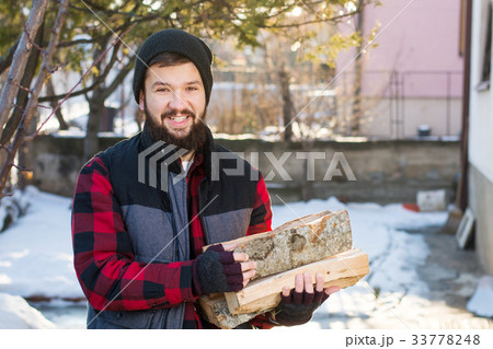 Masculine man carrying firewood 33778248