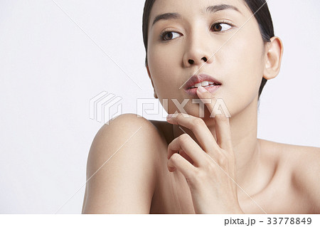 portrait of a female model posing with her hand on lips portrait of a female model posing with her hand on lips 33778849
