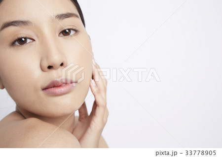 a girl is touching her face and looking at something 33778905