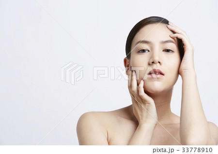 an attractive girl is putting her hand on her face an attractive girl is putting her hand on her face 33778910