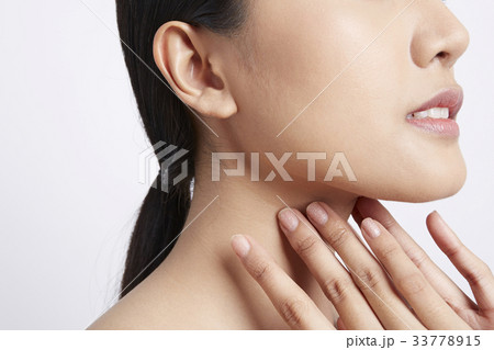 a girl is touching fingers on her neck 33778915