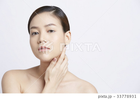 a beautiful girl is putting a hand on her neck 33778931