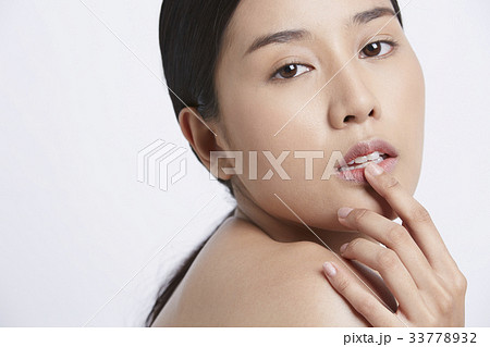 a beautiful girl is touching a finger on her mouth 33778932