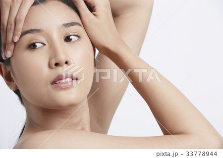 a girl is putting her hands on her head and looking away 33778944