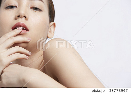 an attractive girl is putting fingers on her lip 33778947