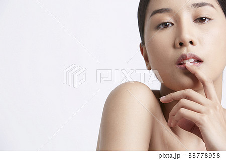 a beautiful girl is putting a finger on her lip 33778958