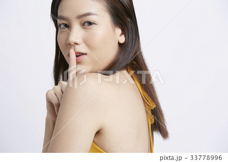 asian girl is showing quiet handsign on white background 33778996