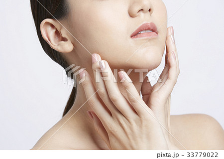 asian beautiful woman is applying moisturizer on her face 33779022