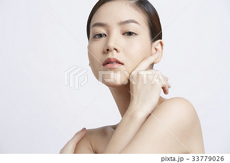 young woman with fresh clean skin is touching her face 33779026