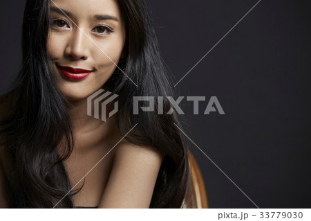 photo of smiling girl with a long curly hair on black background 33779030