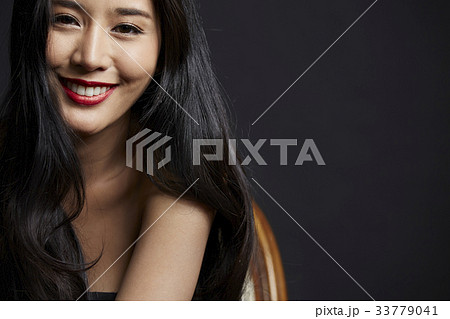 portrait of happy woman with a long black hair posing in studio 33779041
