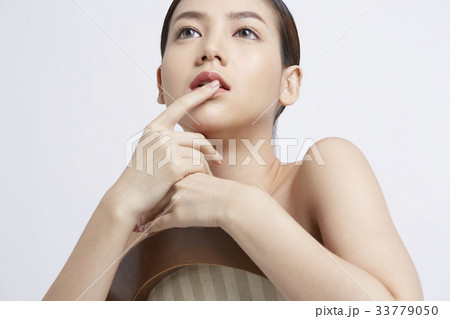 portrait of young beautiful woman touching her lip and thinking 33779050