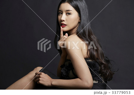 portrait of beautiful woman touching her lips on black background 33779053