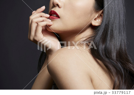 portrait of Asian girl touching her lip on black background 33779117