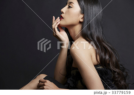 A Thai girl with black hair is posing photo on black background 33779159