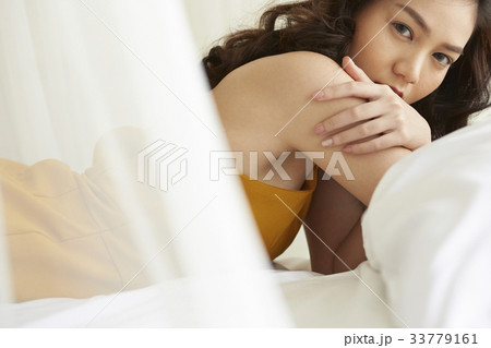Portrait of beautiful young lady relaxing lying in bed 33779161