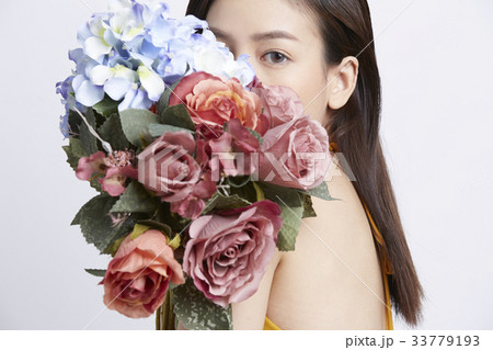 portrait of a girl hiding after flowers 33779193