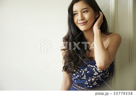 photo of a woman leaning against a wall and smiling. 33779338
