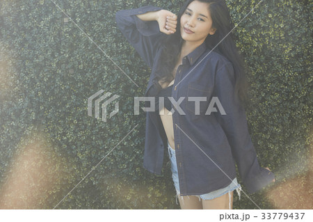 portrait of a woman standing outside, posing and smiling portrait of a woman standing outside, posing and smiling 33779437