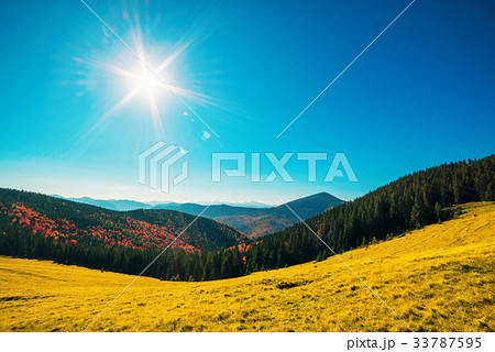 Orange mountains and sun in blue sky 33787595