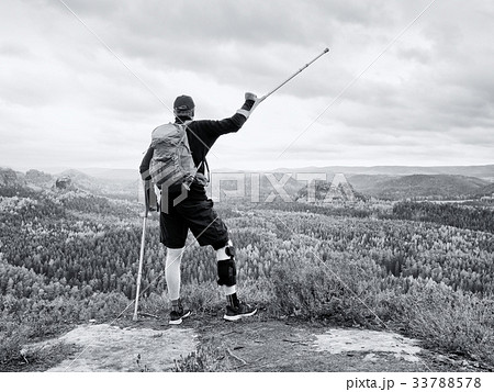 Disabled man on crutches on rock. Hurt knee  33788578