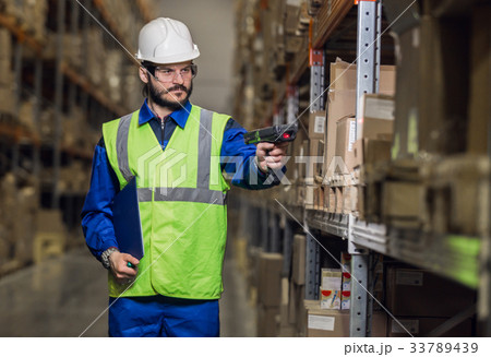 Man checking cargo on shelves with scanner 33789439