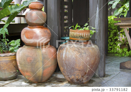 Old orange earthen jars stacked next to a wooden Old orange earthen jars stacked next to a wooden 33791182