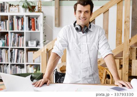 Young man standing in creative office Young man standing in creative office 33793330