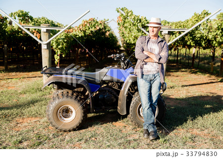 Man standing next to truck in vineyard Man standing next to truck in vineyard 33794830