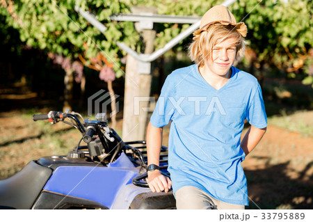 Boy standing next to truck in vineyard 33795889