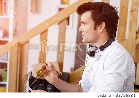 Portrait of young man sitting at the stairs in office Portrait of young man sitting at the stairs in office 33796831