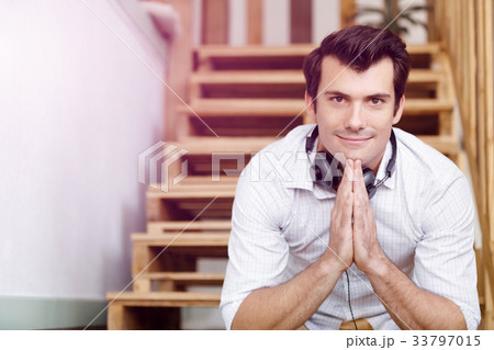 Portrait of young man sitting at the stairs in office Portrait of young man sitting at the stairs in office 33797015