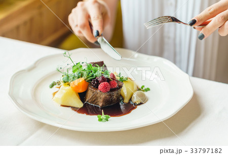 women eating beef steak with berry sauce women eating beef steak with berry sauce 33797182