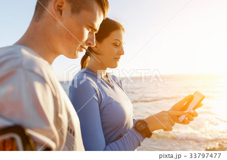 Young couple with smartphones outdoors Young couple with smartphones outdoors 33797477