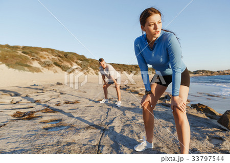 Young couple on beach training together 33797544