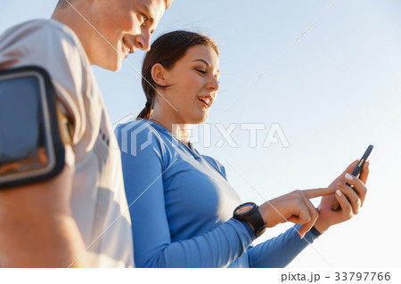 Young couple with smartphones outdoors Young couple with smartphones outdoors 33797766