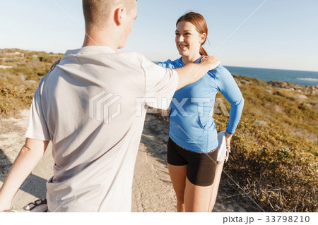 Young couple on beach training together Young couple on beach training together 33798210