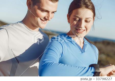 Runner woman with heart rate monitor running on beach 33798227