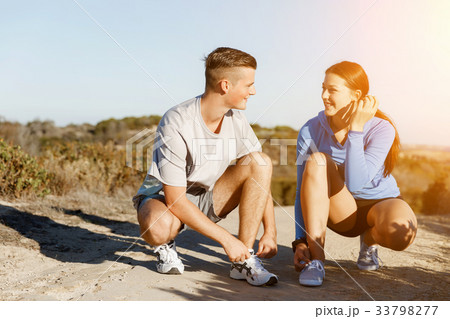 Couple of runners lace their shoes and prepare to jogging 33798277