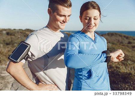 Runner woman with heart rate monitor running on beach 33798349