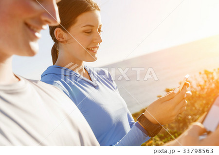 Young couple with smartphones outdoors 33798563