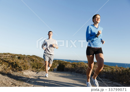 Sport runner jogging on beach working out with her partner Sport runner jogging on beach working out with her partner 33799071