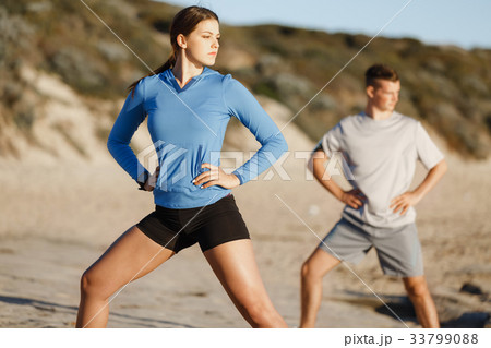 Young couple on beach training together Young couple on beach training together 33799088